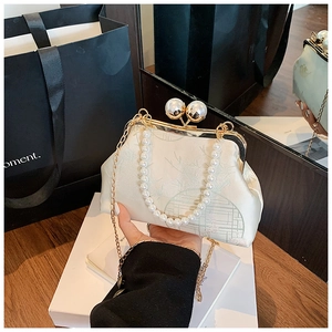 Detailed shot of Chinese style satin handbag featuring pearl clasp and elegant floral embroidery