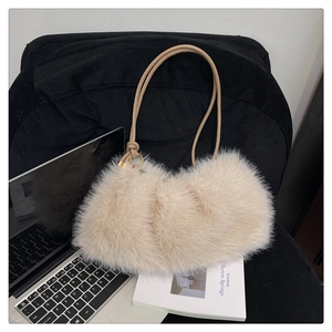 Detailed view of beige faux fur bucket bag with soft plush texture and golden ring detail