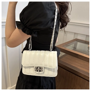 Detail of white quilted leather bag with silver chain strap and crystal buckle shown on model