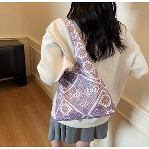 Vista posteriore della modella con borsa tote in maglia etnica viola e bianca a motivi