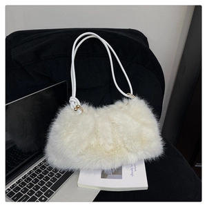 Detail of white faux fur shoulder bag featuring golden metallic rings and ball clasp accents