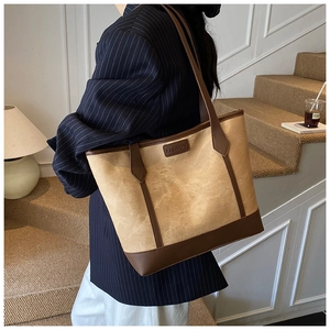 Detail of vintage canvas and leather tote with FASHION tag worn on shoulder