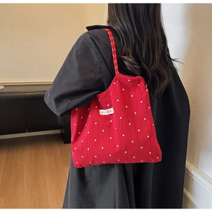 Détail du sac cabas rouge à fleurs en mousseline avec tissu texturé et poignée en corde