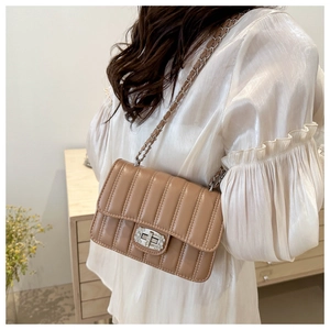 Detail of light brown quilted bag with rhinestone twist lock and chain strap