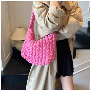 Close-up of bright pink popcorn fabric texture on a large stylish shoulder bag