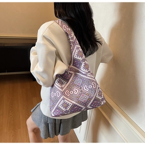 Dettaglio della trama pixel geometrica viola e bianca su una borsa tote a tracolla