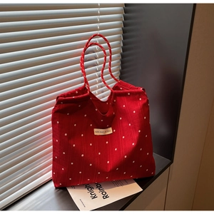 Détail du grand sac cabas rouge à fleurs avec anses en corde et étiquette