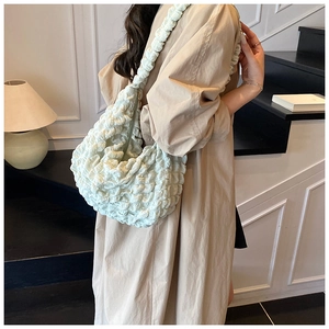 Close-up of mint green pleated shoulder bag with unique bubble texture and metal zipper