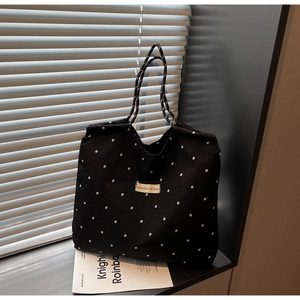 Détail du sac cabas floral en mousseline avec poignées en corde sur un rebord de fenêtre