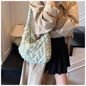 Close-up of a light green hobo bag featuring bubble texture and ruched handle detail