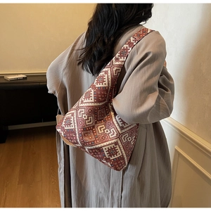 Dettaglio del ricamo geometrico vintage sulla borsa tote in tela marrone e rossa