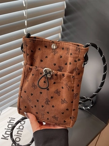 Brown corduroy crossbody bag with heart bow print and stylish black white rope strap