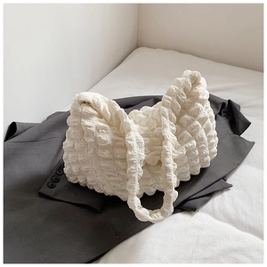 Detailed view of off-white bubble texture fabric on a stylish crossbody shoulder bag