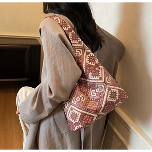 Dettaglio di una grande borsa tote etnica con motivi geometrici rossi e tracolla larga