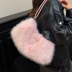 Pink faux fur shoulder bag with woven strap worn by a model in a black jacket