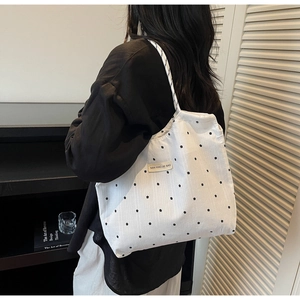 Détail d'un sac cabas blanc à motif floral avec étiquette de marque en tissu