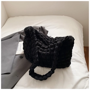 Detail of black textured bubble fabric on large shoulder tote bag with cloud-like pleats