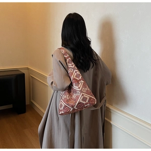 Borsa tote in tela etnica con motivi geometrici abbinata a un trench autunnale