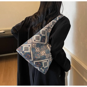 Dettaglio della borsa tote in jacquard con motivo etnico a rombi su una modella