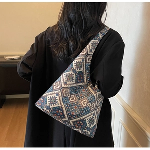 Dettaglio della borsa tote etnica intrecciata con motivi geometrici e vestibilità a spalla