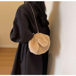 Détail d'un sac lapin en peluche camel avec chaîne dorée et texture en fausse fourrure