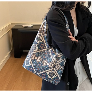 Dettaglio ravvicinato della borsa tote etnica con motivi geometrici tessuti blu e bianchi