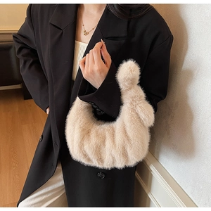 Gros plan d'un sac à main beige en fausse fourrure pelucheuse avec texture douce