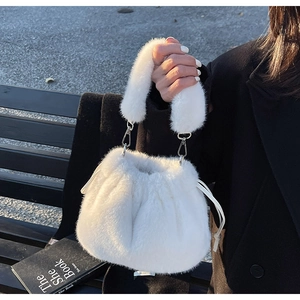 Détail d'un sac à main blanc en fausse fourrure avec peluche douce et boucles argentées