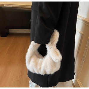 Détail d'un sac à main en fausse fourrure blanche douce avec poignée à nœud en décor intérieur