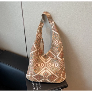 Dettaglio del ricamo etnico e della fibbia magnetica sulla borsa tote color crema