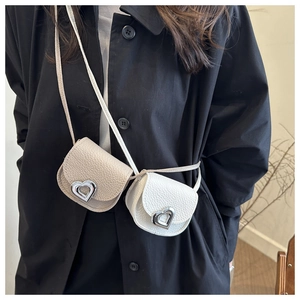 Close-up of heart-shaped silver buckles and lychee texture on mini crossbody bags