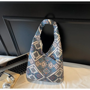 Dettaglio borsa hobo con stampa etnica geometrica, tasca frontale e bottone a pressione in metallo