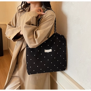 Close-up of floral chiffon tote bag with letter label and black white daisy patterns