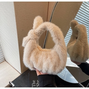 Détail d'un sac à main en fausse fourrure beige avec une poignée nouée élégante