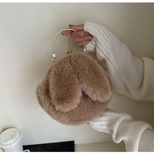 Détail du sac à main en peluche lapin avec poignée en métal doré et fermoir perle chic