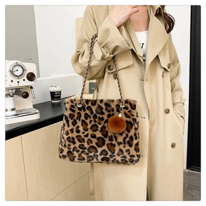 Close-up of leopard faux fur shoulder bag with chain strap and brown pompom charm