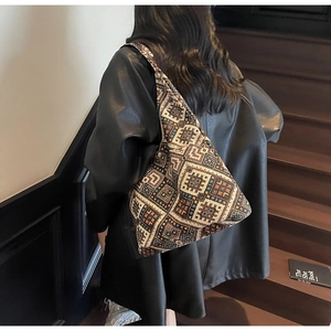 Dettaglio della borsa tote etnica con motivi tessuti geometrici colorati e ricami a punto croce