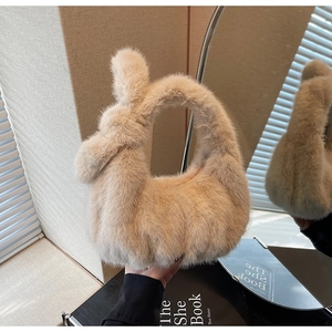 Détail d'un sac à main en peluche avec poignée torsadée dans un ton beige doux