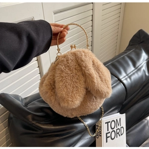 Détail du sac à main en fausse fourrure marron avec oreilles de lapin et poignée dorée