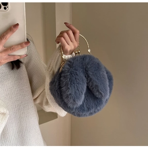 Détail d'un sac lapin bleu pelucheux avec fermoir doré et poignée fleurie élégante