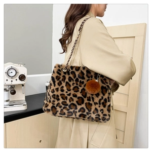 Detail of leopard print faux fur shoulder bag with metal chain strap and pompom accessory