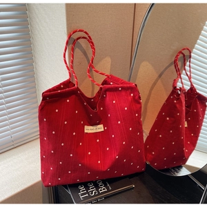 Détail du sac cabas en mousseline rouge avec motifs fleurs blanches et anses en corde