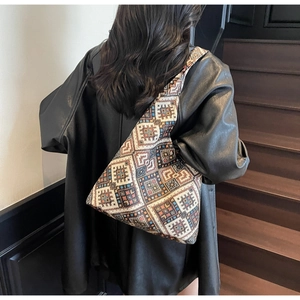 Vista posteriore di una borsa tote etnica con motivi geometrici indossata da una modella