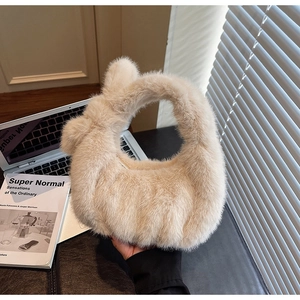 Gros plan du sac à main en peluche beige sur un bureau avec des ombres de lumière naturelle