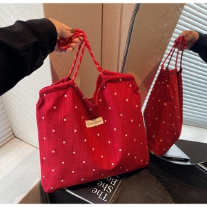 Gros plan sur le sac cabas en mousseline rouge à fleurs avec anses en corde