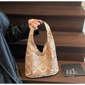 Dettaglio borsa hobo etnica con motivo jacquard geometrico su scale in legno scuro