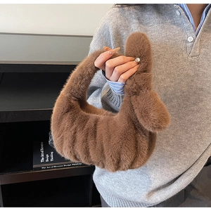 Détail de la texture en fausse fourrure et poignée nouée sur un sac à main marron