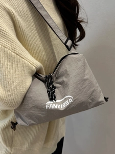 Minimalistische beige Nylon-Umhängetasche mit Logo, von Model im Freizeitstil getragen