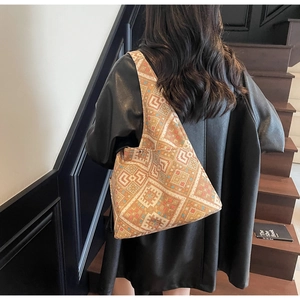 Borsa hobo con stampa etnica geometrica indossata da una modella su una scala