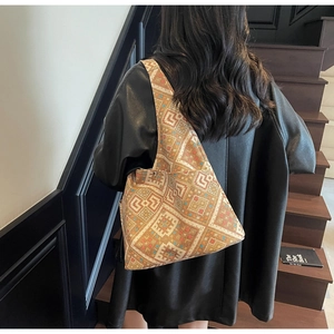 Dettaglio della borsa tote bohémien con motivi geometrici indossata a spalla in città